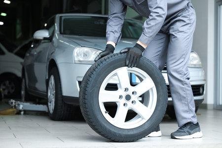 Mechanic changing tire at car service, closeupの写真素材