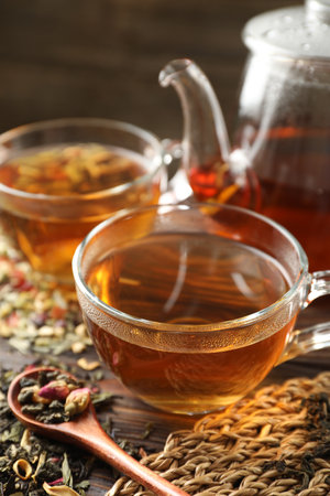 Refreshing herbal tea and dry leaves on wooden table, closeupの写真素材