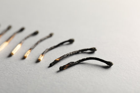 Burnt matches on grey background, closeup viewの写真素材