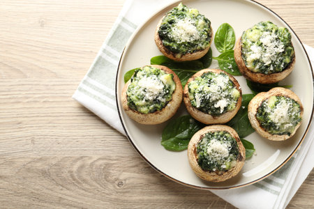 Tasty stuffed mushrooms served on light wooden table, top view. Space for textの写真素材
