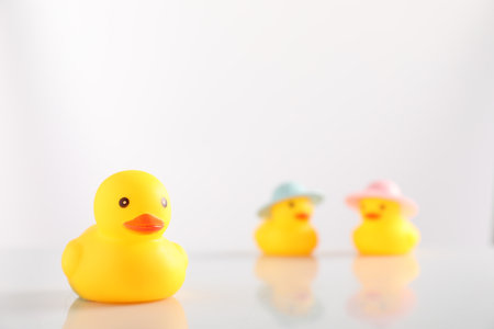 Cute rubber ducks on white background, selective focus. Space for textの写真素材