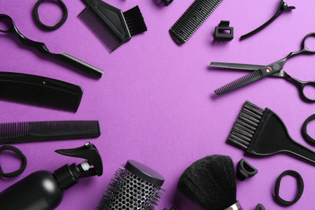 Frame of different hairdresser's tools on violet background, flat lay. Space for textの写真素材
