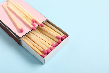 Matches and box on light blue background, closeup. Space for textの写真素材