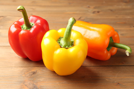 Ripe colorful bell peppers on wooden table, closeupの写真素材