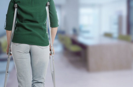 Woman with axillary crutches in hospital, closeup. Space for textの写真素材