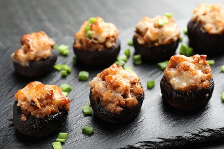 Tasty stuffed mushrooms served on black table, closeupの写真素材