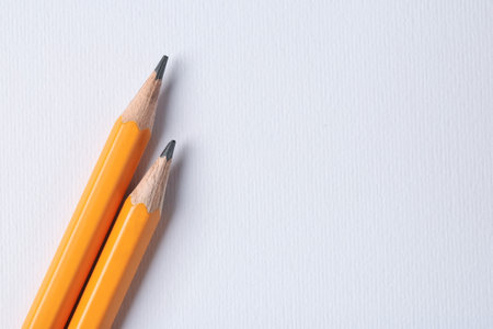 Sharp graphite pencils on light background, top view. Space for textの写真素材