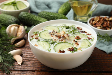 Tasty cucumber soup with dill and nuts in bowl on wooden table, closeupの写真素材