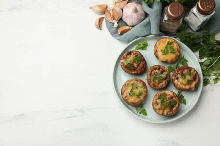 Tasty stuffed mushrooms and spices on white marble table, flat lay. Space for textの写真素材