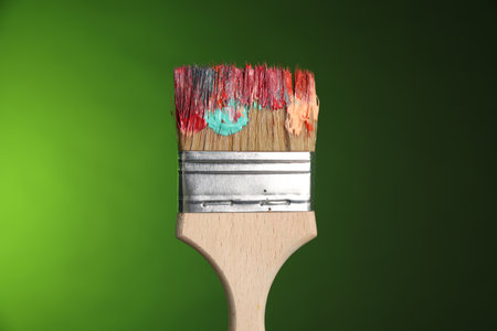 One dirty paintbrush on green background, closeupの写真素材