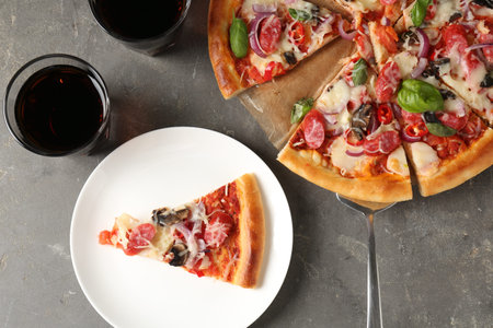 Slice of tasty pizza with thin smoked sausages served on grey table, flat layの写真素材