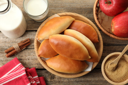 Tasty baked patties and ingredients on wooden table, flat layの写真素材