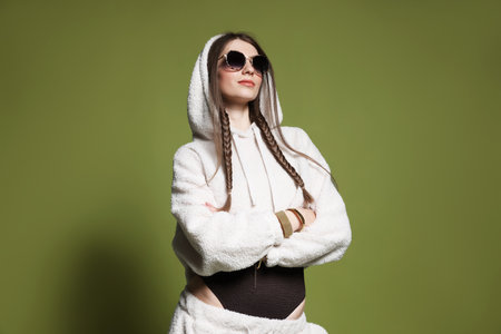 Fashionable portrait of beautiful woman in stylish outfit on green backgroundの写真素材