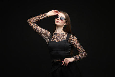 Fashionable portrait of beautiful woman in stylish outfit on black backgroundの写真素材