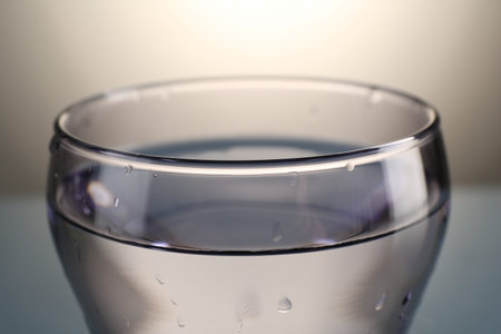 Fresh water in glass on gray gradient background, closeup