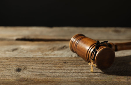 Judge's gavel and cross on wooden table, closeup. Space for textの写真素材