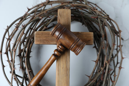 Judge's gavel, wooden cross and crown of thorns on white marble table, top viewの写真素材