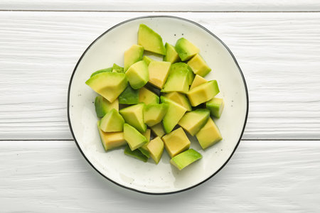 Tasty cut avocados on white wooden table, top viewの写真素材