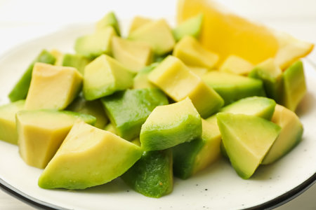 Tasty cut avocados and lemon on white table, closeupの写真素材