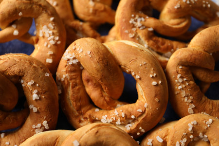 Tasty pretzels with salt on plate, closeup