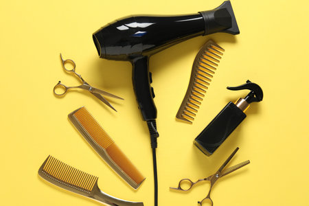 Different hairstyling tools on yellow background, flat layの写真素材