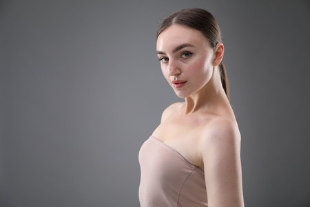 Portrait of beautiful woman on grey background. Space for textの写真素材