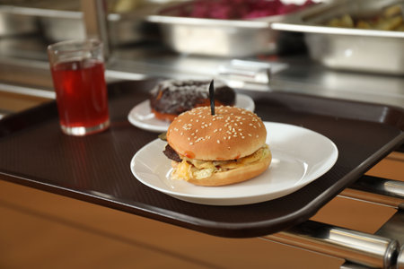 Plastic tray with tasty food near serving line in school canteenの写真素材