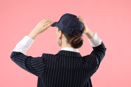 Woman in stylish baseball hat on pink background, back viewの写真素材