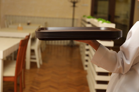 School canteen worker holding plastic trays for food indoors, closeupの写真素材