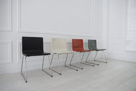 Colorful chairs near white wall in waiting room