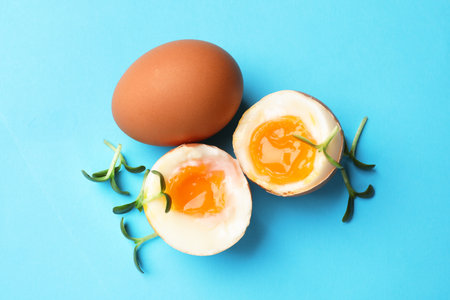 Soft boiled eggs with microgreens on light blue background, top viewの写真素材