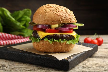 Delicious hamburger with patty and cheese on wooden table, closeupの写真素材