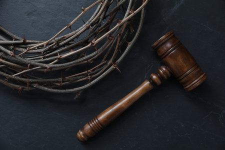 Judge's gavel and crown of thorns on black table, flat layの写真素材