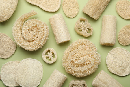 Natural loofah sponges on green background, flat layの写真素材