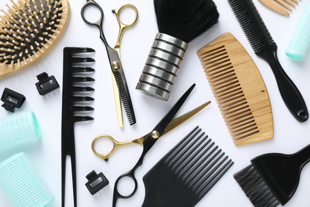Different hairdresser's tools on white background, flat lay