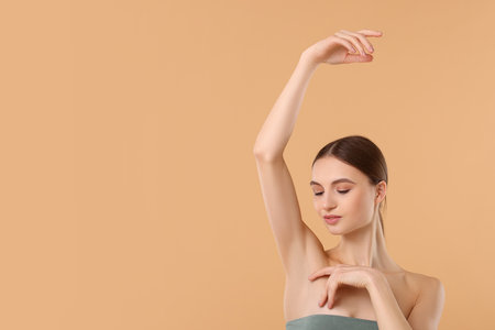 Young woman showing smooth skin after epilation on beige background, space for textの写真素材