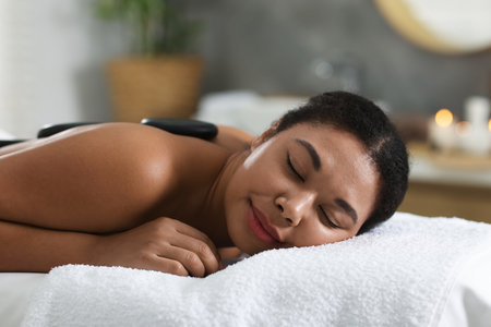 Beautiful woman relaxing on massage couch in spa salonの写真素材
