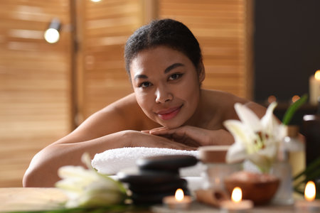 Beautiful woman relaxing on massage couch in spa salonの写真素材