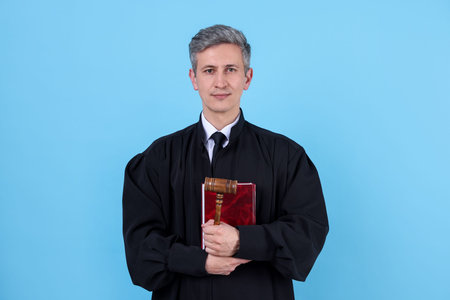 Judge with book on light blue background