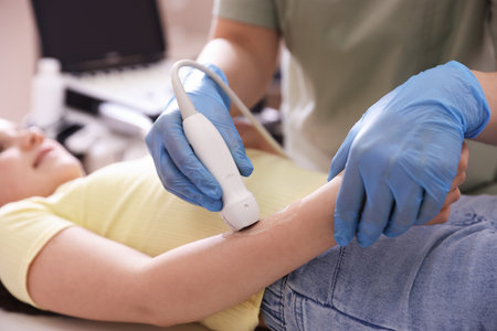 Sonographer conducting ultrasound examination of girl's arm in clinic, closeupのeditorial素材