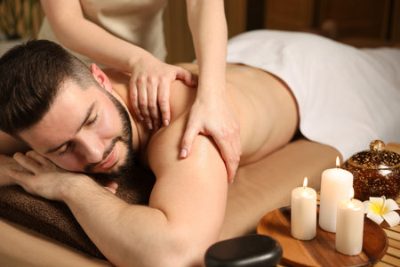 Man receiving relaxing massage in spa salonの写真素材