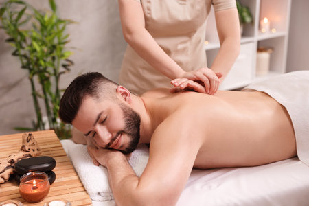 Man receiving relaxing massage in spa salonの写真素材