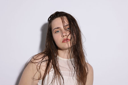 Portrait of beautiful woman with natural skin complexion on light grey background, closeupの写真素材