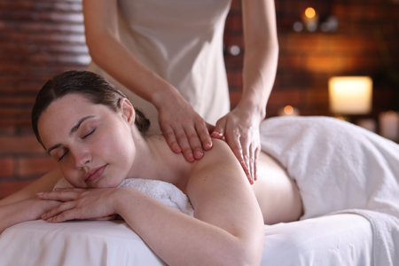 Woman receiving back massage with oil in spa salonの写真素材