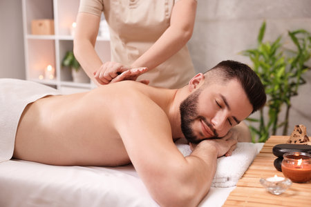 Man receiving relaxing massage in spa salonの写真素材