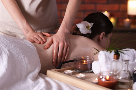 Woman receiving back massage with oil in spa salonの写真素材