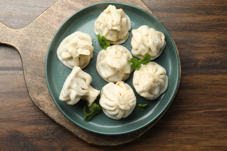 Delicious khinkali with cilantro on wooden table, top viewの写真素材