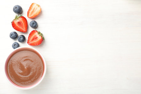 Baby food. Tasty puree in bowl and different ingredients on white wooden table, flat lay. Space for textの写真素材