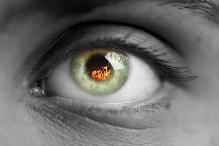 Woman with fire burning in her eye, closeup. Black and white effectの写真素材