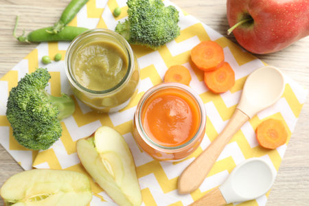 Baby food. Tasty puree in jars and ingredients on wooden table, flat layの写真素材